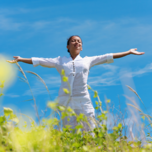 Happy woman in field with arms outstretched
